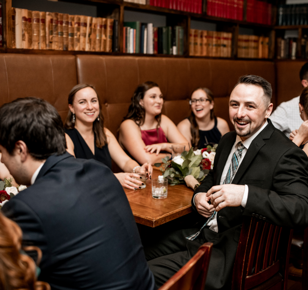A group of elegantly dressed men and women sharing laughter and smiles